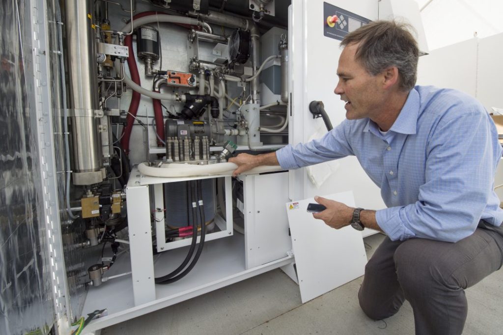 Jack Brouwer, UCI associate professor of mechanical & aerospace engineering and civil & environmental engineering, explains the workings of an electrolyzer, a key component of the power-to-gas system. The device uses renewable electricity to split water into oxygen and hydrogen. The oxygen is released into the atmosphere, and the hydrogen is injected into the natural gas supply line for UCI’s power plant. Steve Zylius / UCI